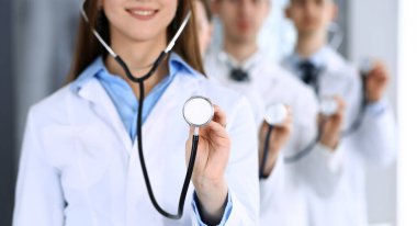 Group of doctors holding stethoscope head close-up. Physicians ready to examine and help patient. Medical help, insurance in health care, best treatment and medicine concept clipart