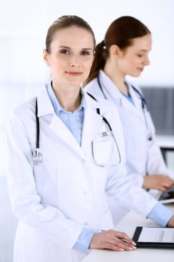 Hastanede çalışan bir grup doktor. Doktor resepsiyonda beklerken tıbbi belge ya da reçete dolduruyor. Tıp ve sağlık hizmetleri kavramındaki veriler