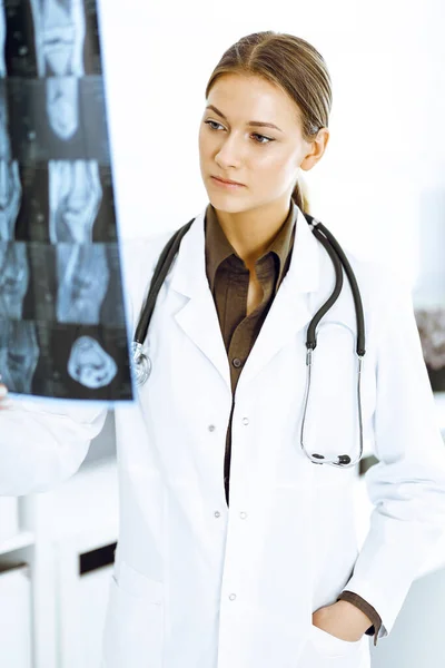 女医生在医院检查X光照片。在诊所工作的外科医生或矫形师 — 图库照片