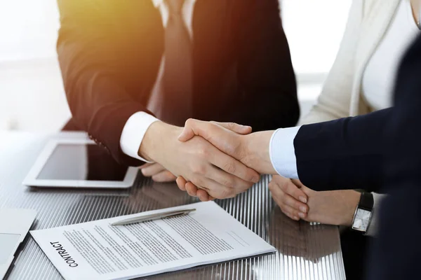 Üzletemberek kezet ráznak, miután aláírták a szerződést a napfényes modern irodában. Csapatmunka és kézfogás — Stock Fotó