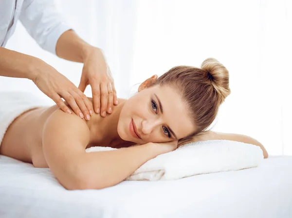 Jeune femme blonde profitant d'un massage du dos dans un salon de spa. Concept de beauté — Photo