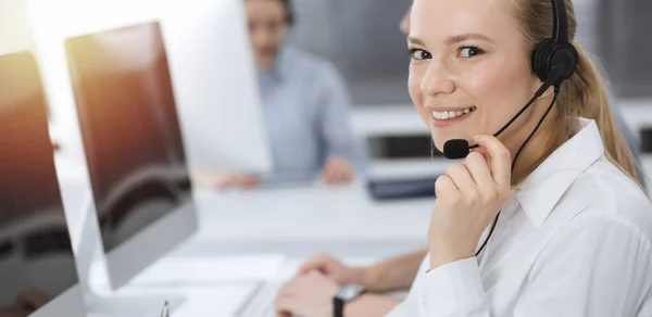 Samtalscentralen. Grupp av tillfälliga klädda operatörer på jobbet. Blond affärskvinna i headset på kundtjänst kontor. Telefonförsäljning i affärer — Stockfoto