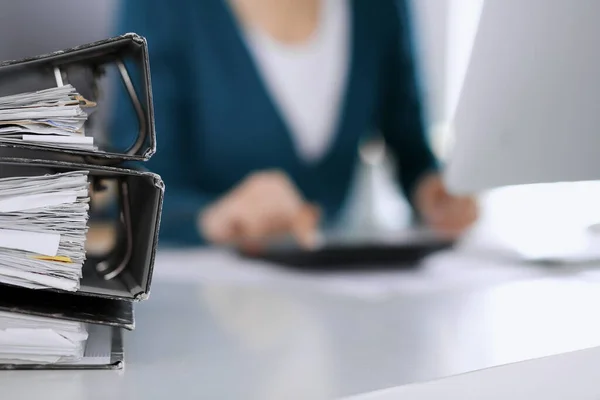 Banner mit Papieren warten darauf, von einer Geschäftsfrau oder Buchhalterin bearbeitet zu werden, die am Schreibtisch im Büro sitzt. Internes Steuer- und Prüfungskonzept — Stockfoto