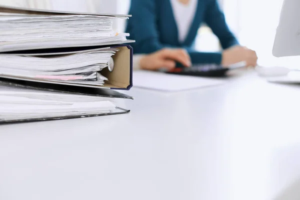 Bnders with papers are waiting to be processed by business woman or bookkeeper working at the desk in office back in blur. Internal Tax and Audit concept — Stock Photo, Image