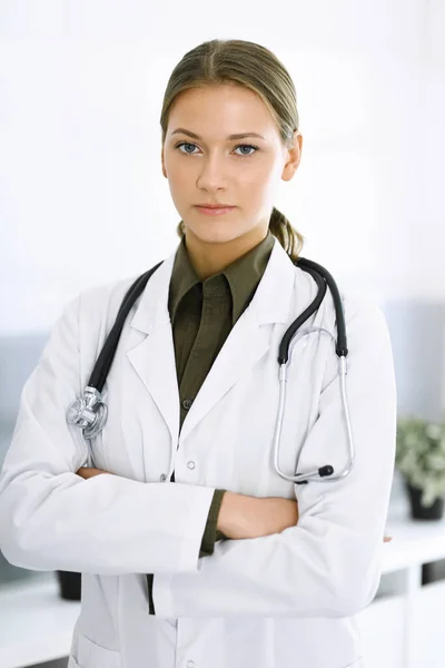 Donna-medico in piedi con le braccia incrociate e guardando la macchina fotografica. Servizio medico perfetto in clinica. Medicina e sanità — Foto Stock