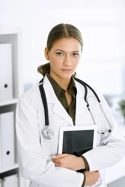 Mujer-médico de pie y mirando a la cámara. Servicio médico perfecto en la clínica. Medicina y asistencia sanitaria — Foto de Stock