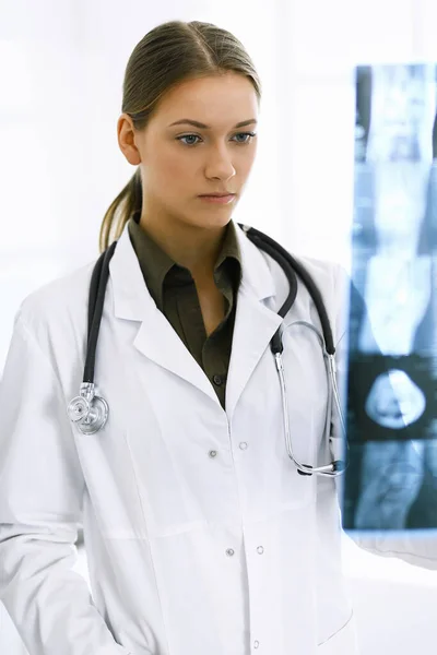 Femme-médecin examinant une photo radiographique à l'hôpital. Chirurgien ou orthopédiste au travail en clinique. Médecine et concept de santé — Photo