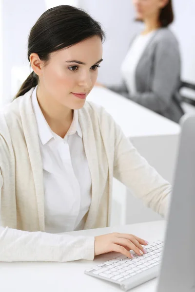 在办公室与计算机打交道的女商人，有背景的女同事。律师或会计师坐在办公桌前工作时的头像 — 图库照片