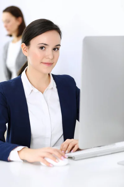 Mujer de negocios que trabaja con la computadora en la oficina, colega de fondo. Imagen de Abogado o Contador en el trabajo mientras está sentado en el escritorio —  Fotos de Stock