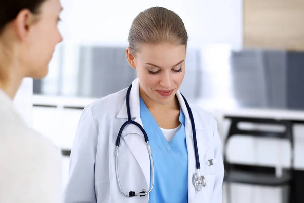 Doctor y paciente durante la consulta. Médico en el trabajo llenando el historial de medicamentos mientras está sentado en el hospital de emergencia, sesión de fotos. Concepto de medicina y salud — Foto de Stock