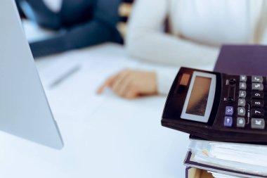 Hesap makinesi ve kağıtlar iş kadını ya da ofisteki büroda çalışan muhasebeci tarafından incelenmeyi bekliyor. İç Denetim ve vergi kavramı