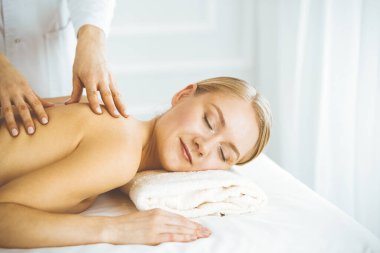 Güzel, mutlu bir kadın gözleri kapalı sırt masajından hoşlanıyor. Güzellik ve Spa salonu konsepti