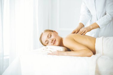 Güzel, mutlu bir kadın gözleri kapalı sırt masajından hoşlanıyor. Güzellik ve Spa salonu konsepti