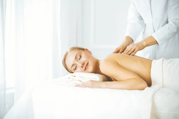 Beautiful happy woman enjoying back massage with closed eyes. Beauty and Spa salon concept — Stock Photo, Image