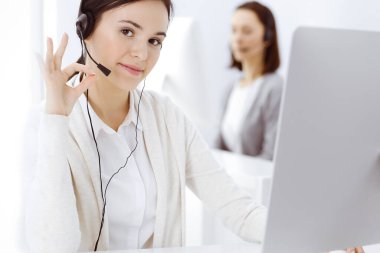 Merkezi ara. Müşteri hizmetleri ofisinde kulaklıkla otururken 