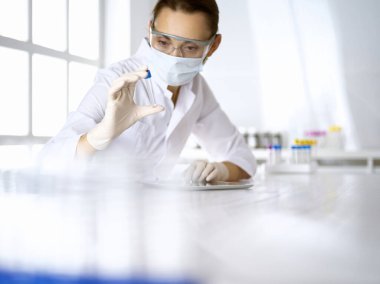 Kadın laboratuvar asistanı hastanede kan örneğini inceliyor. Tıp, sağlık ve araştırma konsepti