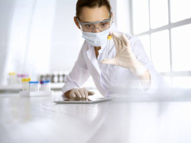 Kadın laboratuvar asistanı hastanede kan örneğini inceliyor. Tıp, sağlık ve araştırma konsepti