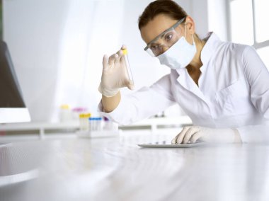 Kadın laboratuvar asistanı hastanede kan örneğini inceliyor. Tıp, sağlık ve araştırma konsepti