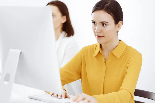 Бізнес-леді в гірчичній кольоровій блузці дивиться на камеру в офісі, знімок — стокове фото