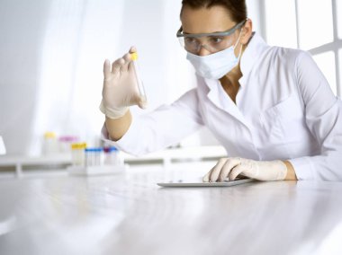 Kadın laboratuvar asistanı hastanede kan örneğini inceliyor. Tıp, sağlık ve araştırma konsepti