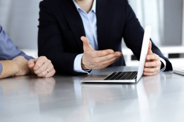 Modern ofiste birlikte çalışırken dizüstü bilgisayarı kullanan iş adamları. İş yerinde iş arkadaşı olan tanınmamış bir iş adamı ya da erkek girişimci. Takım çalışması ve ortaklık kavramı