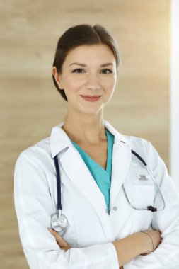 Doktor kadın ayakta kameraya bakıyor. Hekim iş başında. İlaç ve sağlık hizmetleri kavramı