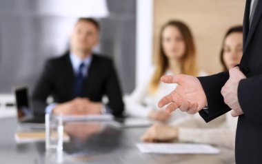 İş sunumu. İş adamı, şirket toplantısında ya da konferansta meslektaşlarına konuşma yapıyor. Hoparlörleri kapatıyor.