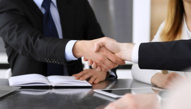 İş adamı, modern ofiste iş arkadaşı veya ortağıyla el sıkışıyor. Yakın plan. Toplantıda bilinmeyen iş adamları var. Takım çalışması, ortaklık ve el sıkışma kavramı