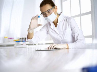 Kadın laboratuvar asistanı hastanede kan örneğini inceliyor. Tıp, sağlık ve araştırma konsepti