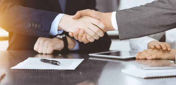 Handdruk als succesvol onderhandelingsresultaat, close-up. Onbekende zakenmensen schudden elkaar de hand na het tekenen van een contract in een modern kantoor — Stockfoto