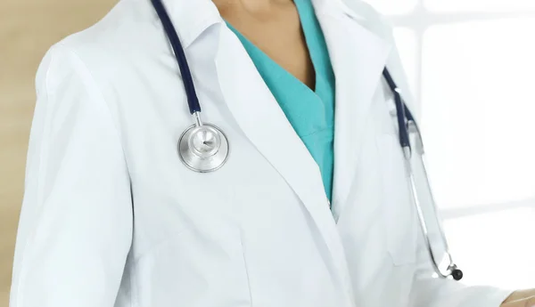알 수없는 여성 의사가 클리닉에 앉아서 태블릿 컴퓨터를 사용하고 있습니다. 의학적 개념 — 스톡 사진
