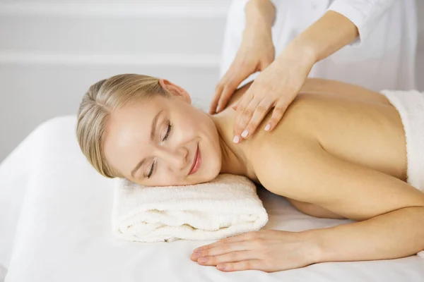 Hermosa mujer caucásica disfrutando de masaje de espalda con los ojos cerrados. Concepto de salón de belleza y spa — Foto de Stock