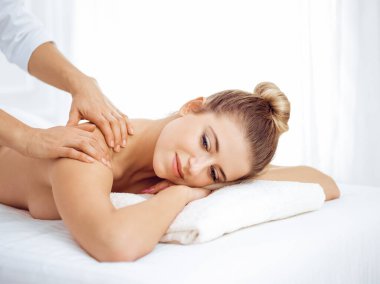 Genç ve sarışın kadın masaj salonunun keyfini çıkarıyor. Güzellik konsepti