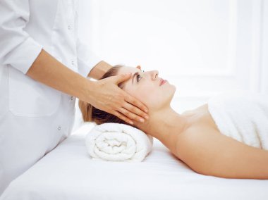 Genç ve sarışın kadın spa salonunda yüz masajından zevk alıyor. Güzellik konsepti