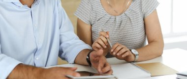 Bilinmeyen iş adamı ve kadın modern bir ofiste bilgisayarla çalışıyor, yakın plan. Çeşitli insanlardan oluşan bir grup. Takım çalışması, ortaklık ve iş konsepti