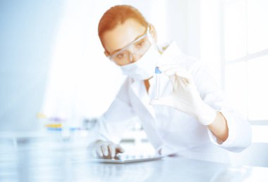 Kadın laboratuvar asistanı hastanede kan örneğini inceliyor. Tıp, sağlık ve araştırma konsepti