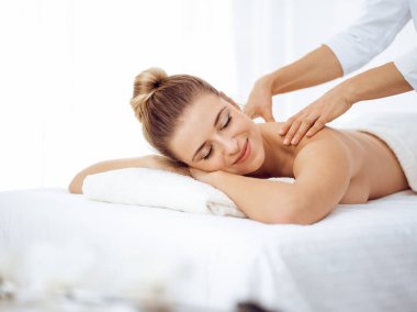 Genç ve sarışın kadın masaj salonunun keyfini çıkarıyor. Güzellik konsepti