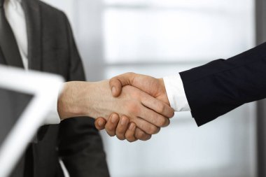 Bilinmeyen iş adamları el sıkışıyorlar. Sözleşme imzalıyorlar. Yakın plan. İş ve tokalaşma kavramı