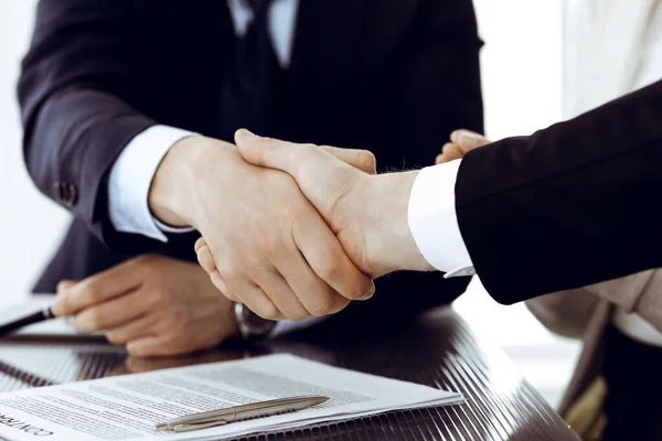 Zakenmensen schudden elkaar de hand na het tekenen van een contract in een modern kantoor. Teamwork, partnerschap en handdruk concept — Stockfoto