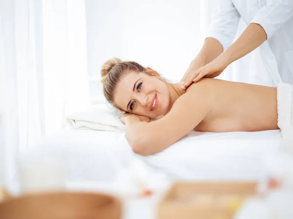 Jeune femme blonde profitant d'un massage du dos dans un salon de spa. Concept de beauté — Photo