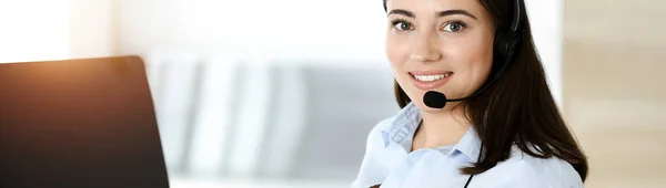 布鲁内特女性客户服务代表使用耳机和在线咨询客户。呼叫中心 — 图库照片