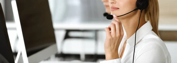 Unknown female customer service representative is consulting clients online using headset.close-up. Call center and business concept