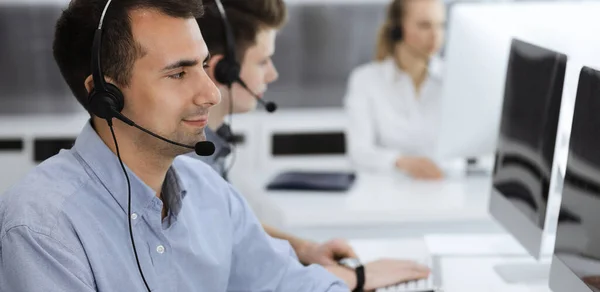 Centro de llamadas. Grupo de operadores vestidos casuales en el trabajo. Hombre de negocios adulto con auriculares en la oficina de servicio al cliente. Telesales en el negocio —  Fotos de Stock