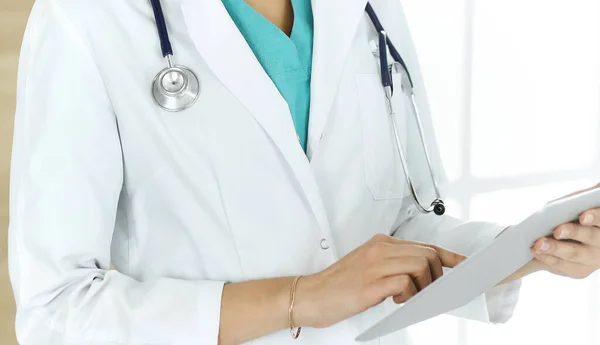 Mujer desconocida médico sentado y el uso de la tableta en la clínica, primer plano. Concepto de medicina — Foto de Stock