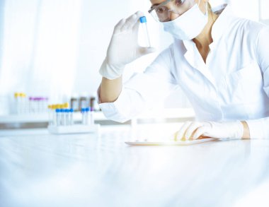 Kadın laboratuvar asistanı hastanede kan örneğini inceliyor. Tıp, sağlık ve araştırma konsepti