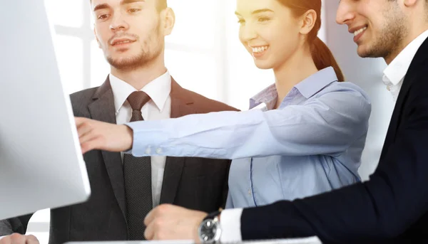 Groep van zakenmensen bespreken vragen op een vergadering in het zonnige kantoor. Collega 's die met computers werken — Stockfoto