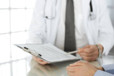 Bilinmeyen erkek doktor ve kadın hasta klinikte oturup pano kullanırken sağlık muayenesini tartışıyorlar. Hastanede iyi bir tıbbi hizmet. Tıp konsepti