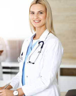 Doktor kadın, Sunny Hastanesi 'nde pano kullanırken ilaç kayıtlarını ve sınav sonuçlarını kontrol ediyor. Tıp ve sağlık hizmetleri kavramı