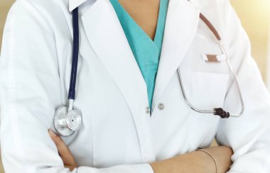 Güneşli klinikte ayakta duran ve röntgen çeken kimliği belirsiz kadın doktor.