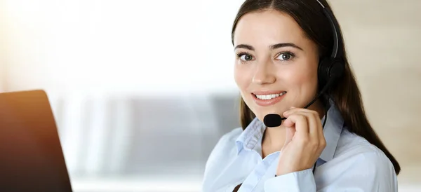Morena representante de servicio al cliente femenino utilizando auriculares y clientes de consultoría en línea. Centro de llamadas — Foto de Stock